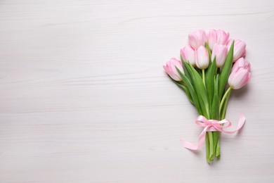 Beautiful pink spring tulips on white wooden background, top view. Space for text