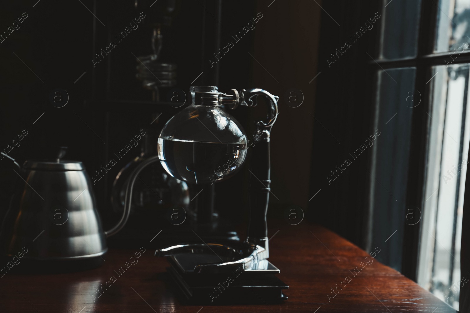 Photo of Vacuum coffee maker on wooden table in cafe