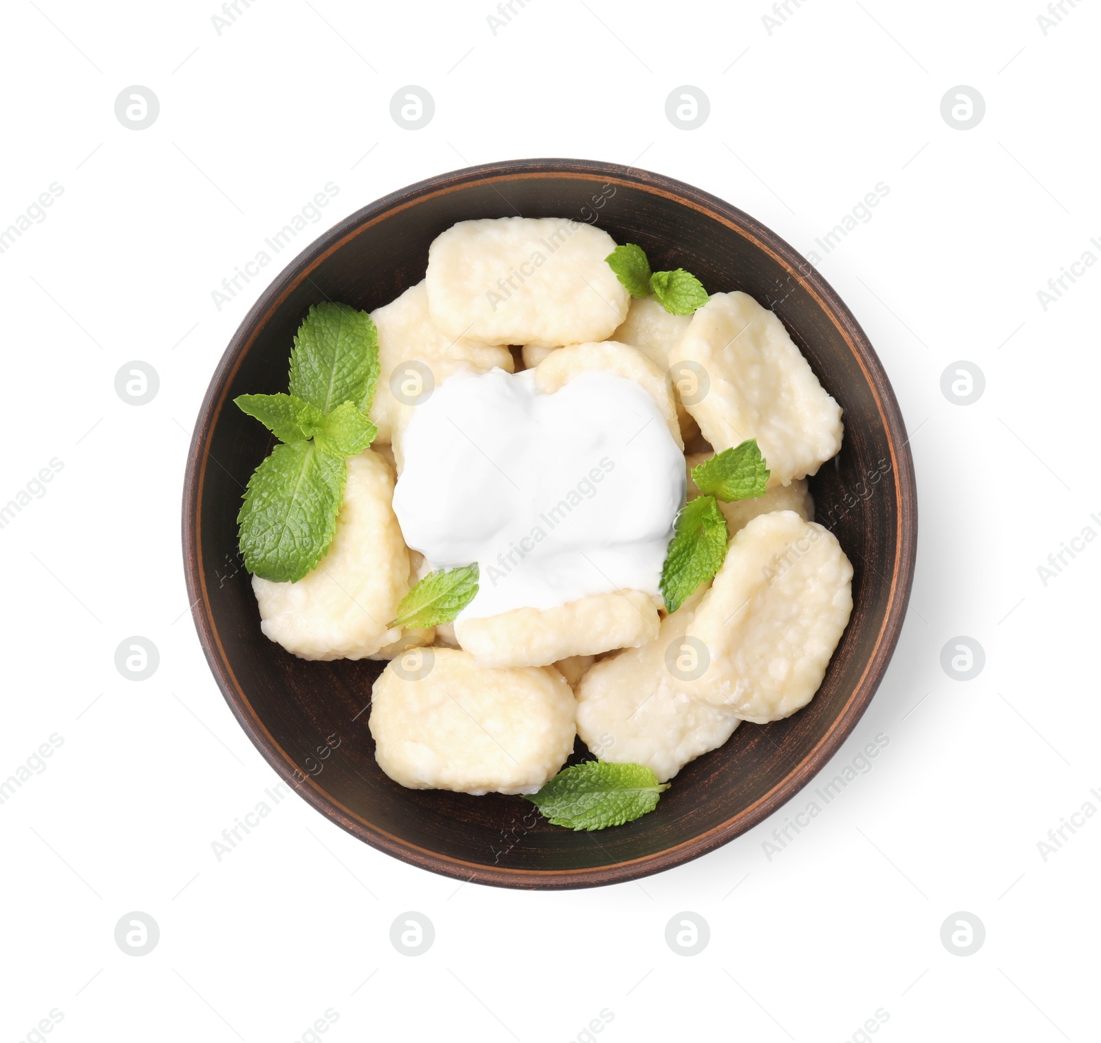 Photo of Bowl of tasty lazy dumplings with mint leaves and sour cream isolated on white, top view