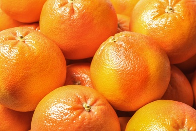 Photo of Many whole fresh ripe grapefruits as background, closeup