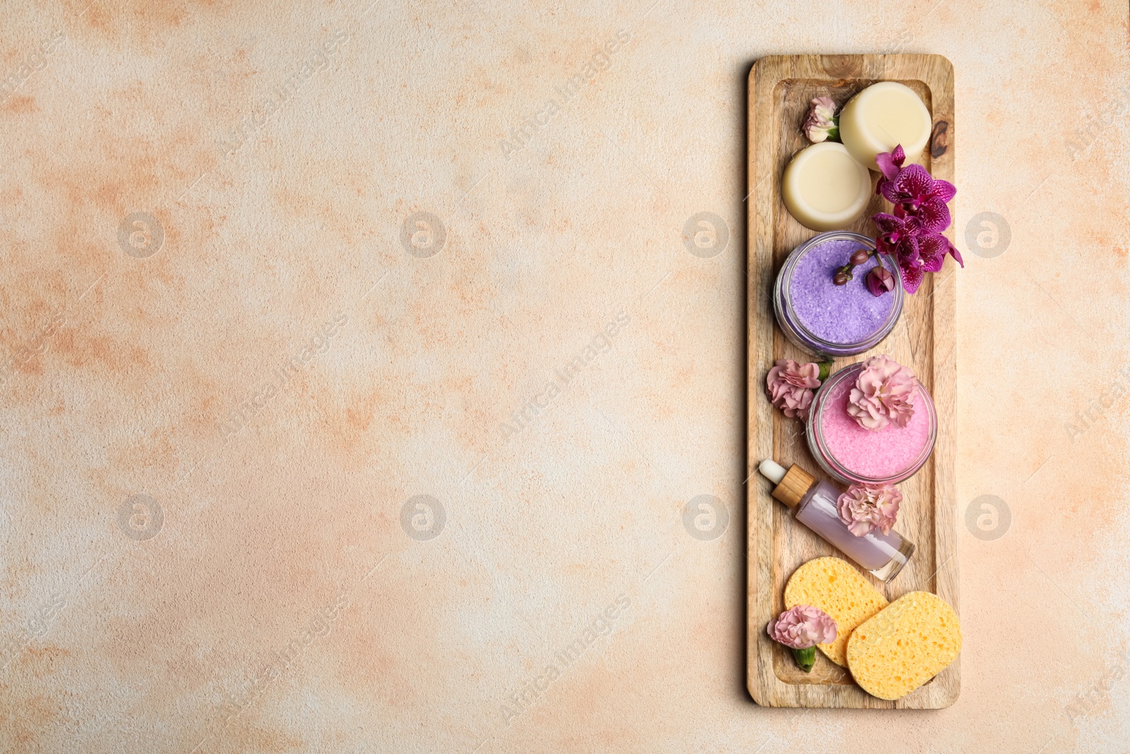 Photo of Aromatic sea salt and spa products on beige textured table, top view. Space for text