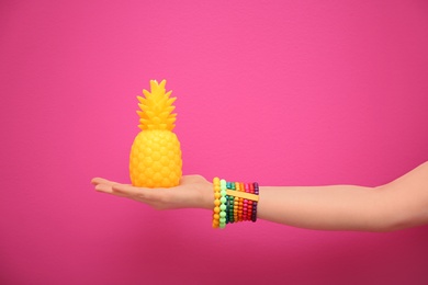 Photo of Woman holding stylish pineapple candle on color background