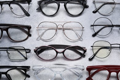 Photo of Many different glasses on light grey background, above view