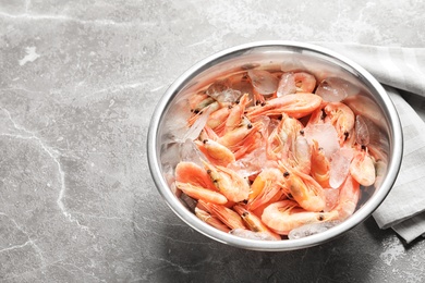 Photo of Bowl with fresh shrimps on gray background