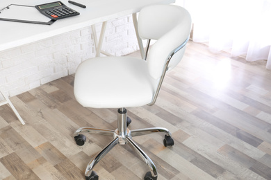 Photo of Comfortable office chair near table in room