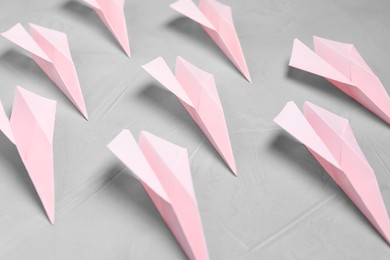 Photo of Many handmade paper planes on light grey table, closeup