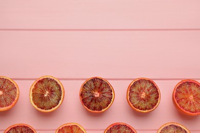 Photo of Many ripe sicilian oranges on pink wooden table, flat lay. Space for text