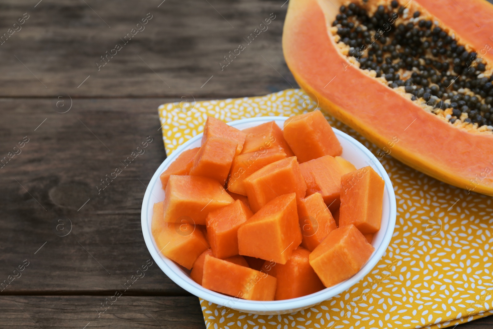 Photo of Tasty ripe cut papaya fruits on wooden table, closeup