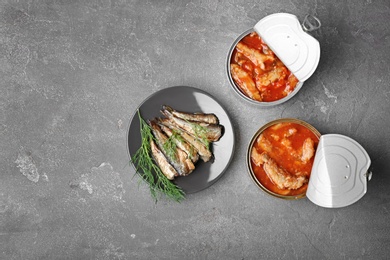 Flat lay composition with canned fish on grey background