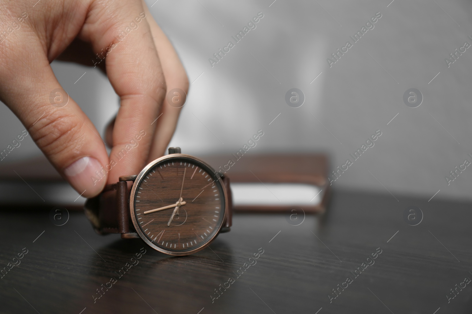 Photo of Man putting luxury wrist watch on table, closeup. Space for text