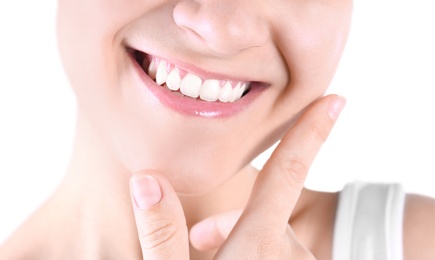 Young woman with beautiful smile on white background, closeup