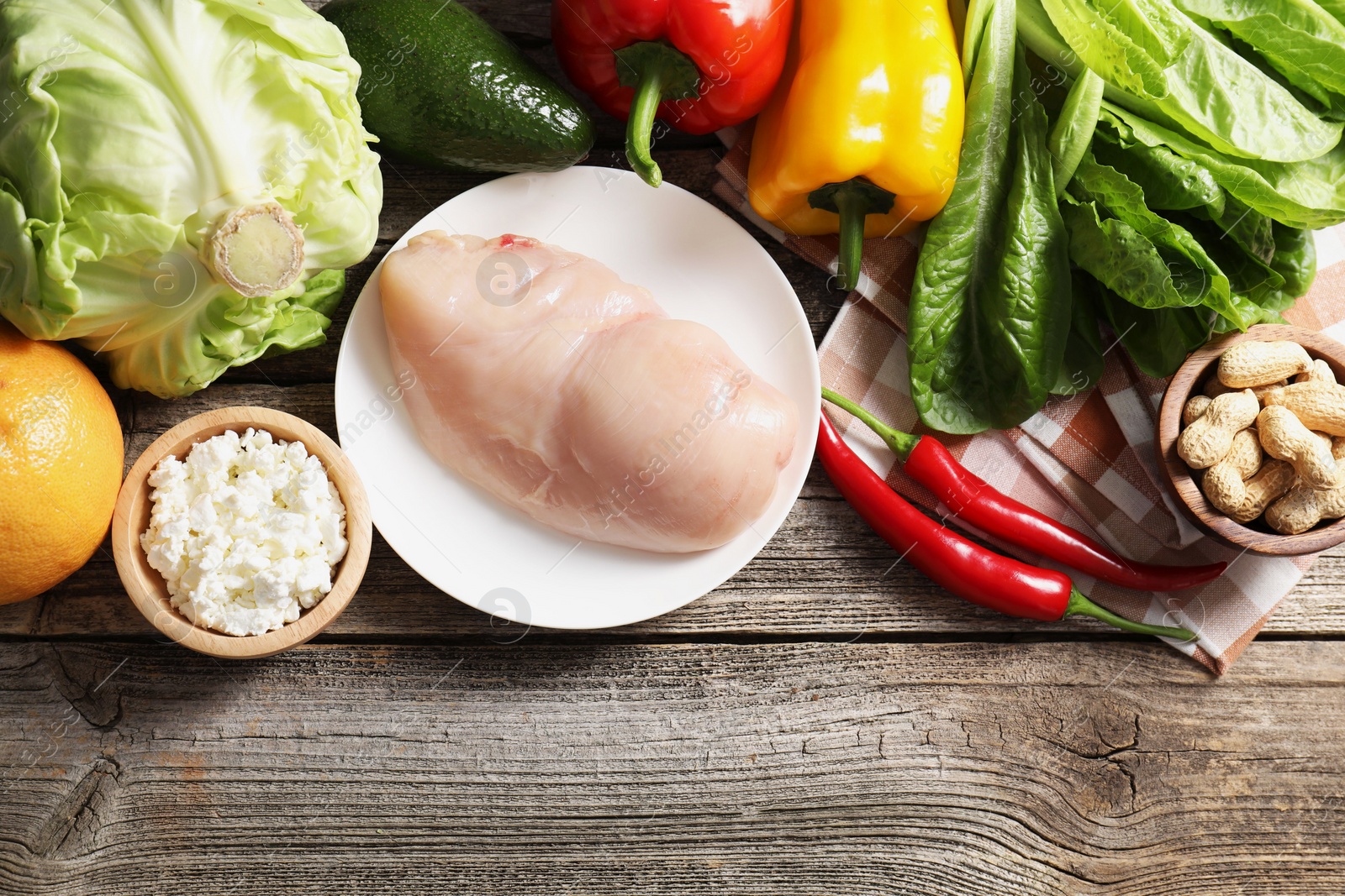 Photo of Healthy meal. Different vegetables and raw chicken breast on wooden table, flat lay