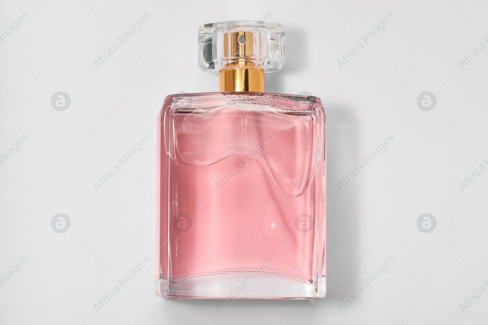 Photo of Pink women's perfume in bottle on white background, top view