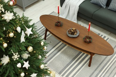 Beautiful Christmas tree and wooden table in cozy room, above view. Interior design