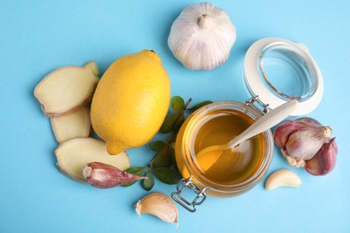 Photo of Flat lay composition with garlic and other cold remedies on blue background