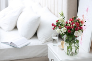 Photo of Glass vase with fresh flowers in bedroom