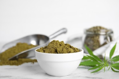 Hemp protein powder and fresh leaves on white marble table, closeup