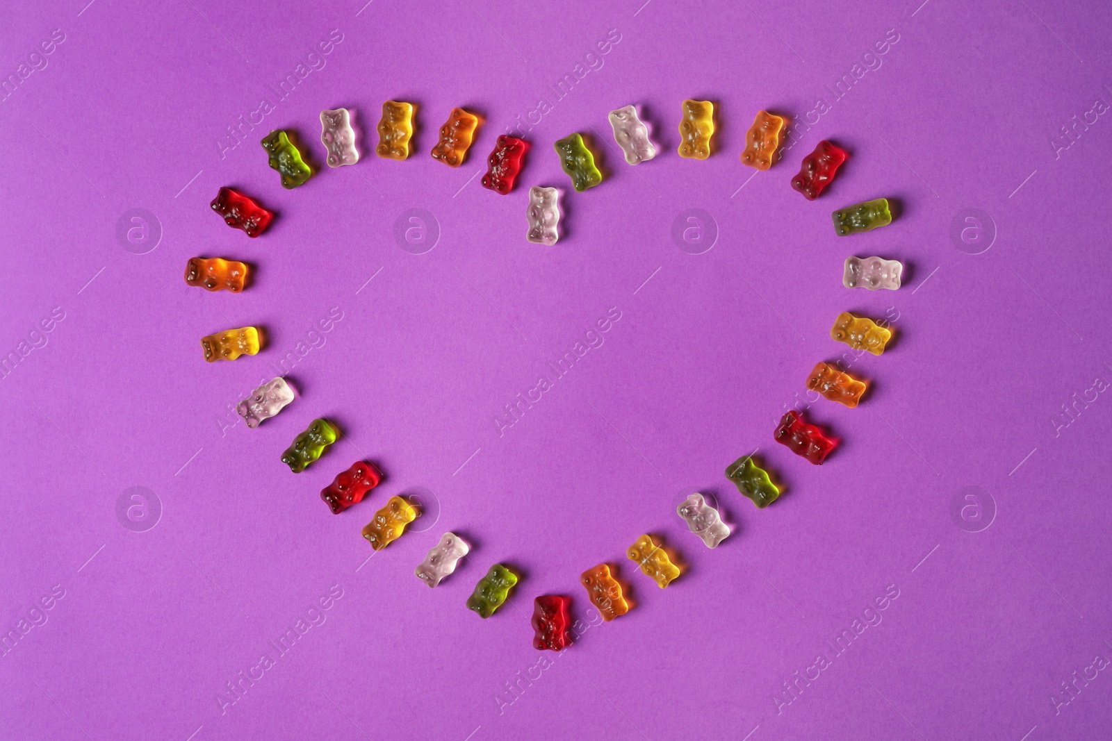 Photo of Flat lay composition with delicious jelly bears on color background. Space for text