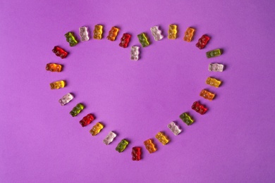 Photo of Flat lay composition with delicious jelly bears on color background. Space for text