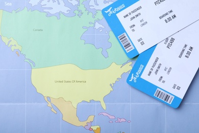 Photo of Tickets on world map, flat lay. Travel agency concept