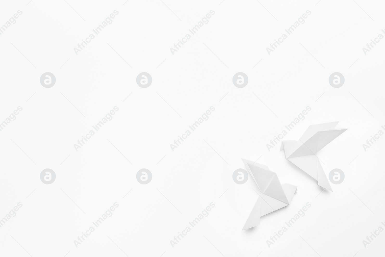 Photo of Beautiful origami birds on white background, flat lay. Space for text