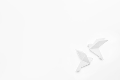 Photo of Beautiful origami birds on white background, flat lay. Space for text