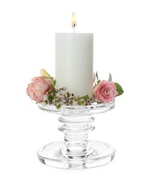 Photo of Glass candlestick with burning candle and floral decor isolated on white