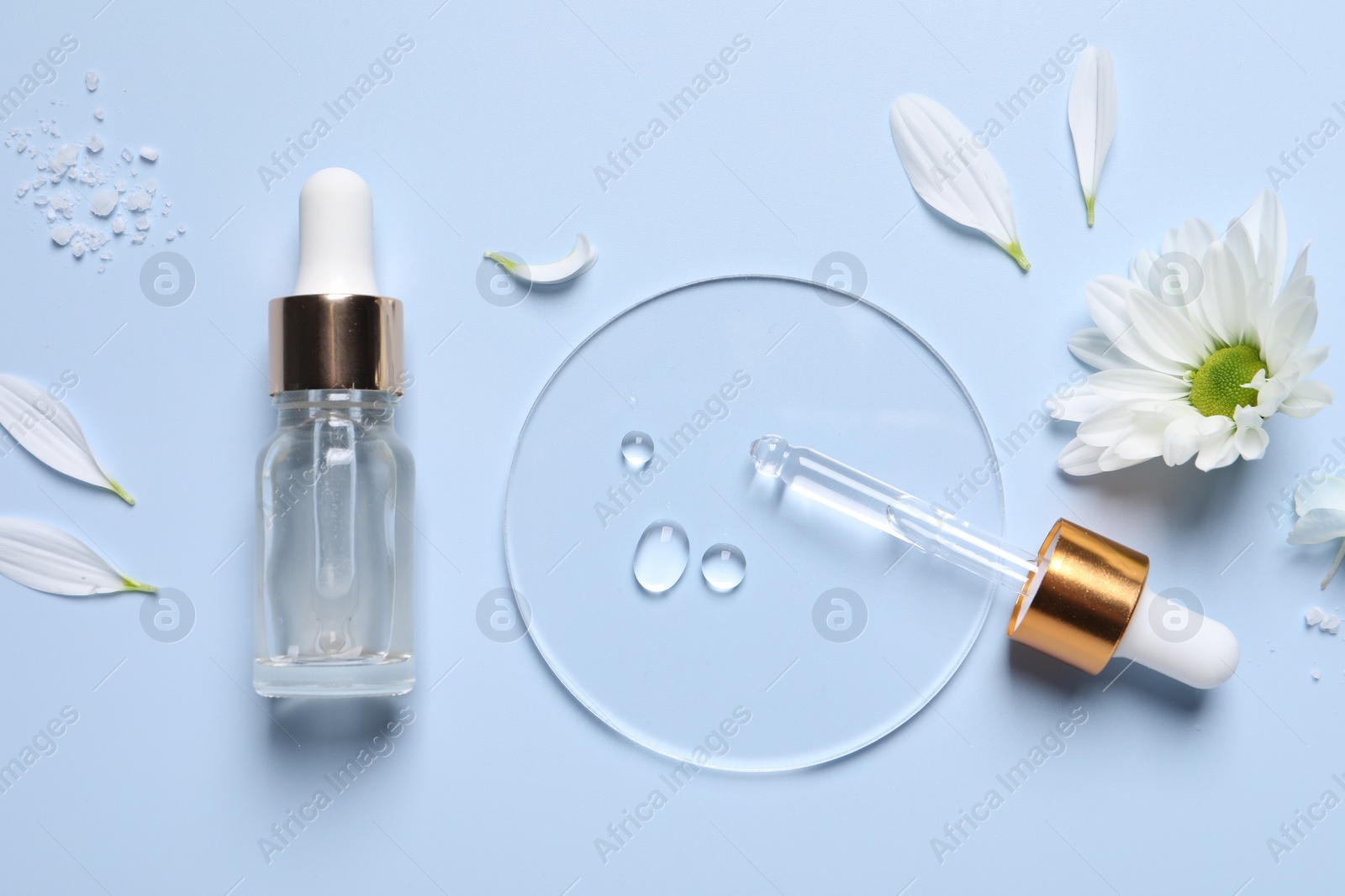 Photo of Bottle of cosmetic serum, pipette and flower on light blue background, flat lay