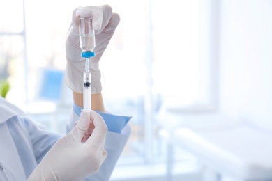 Female doctor with vial and syringe in hospital. Vaccination day