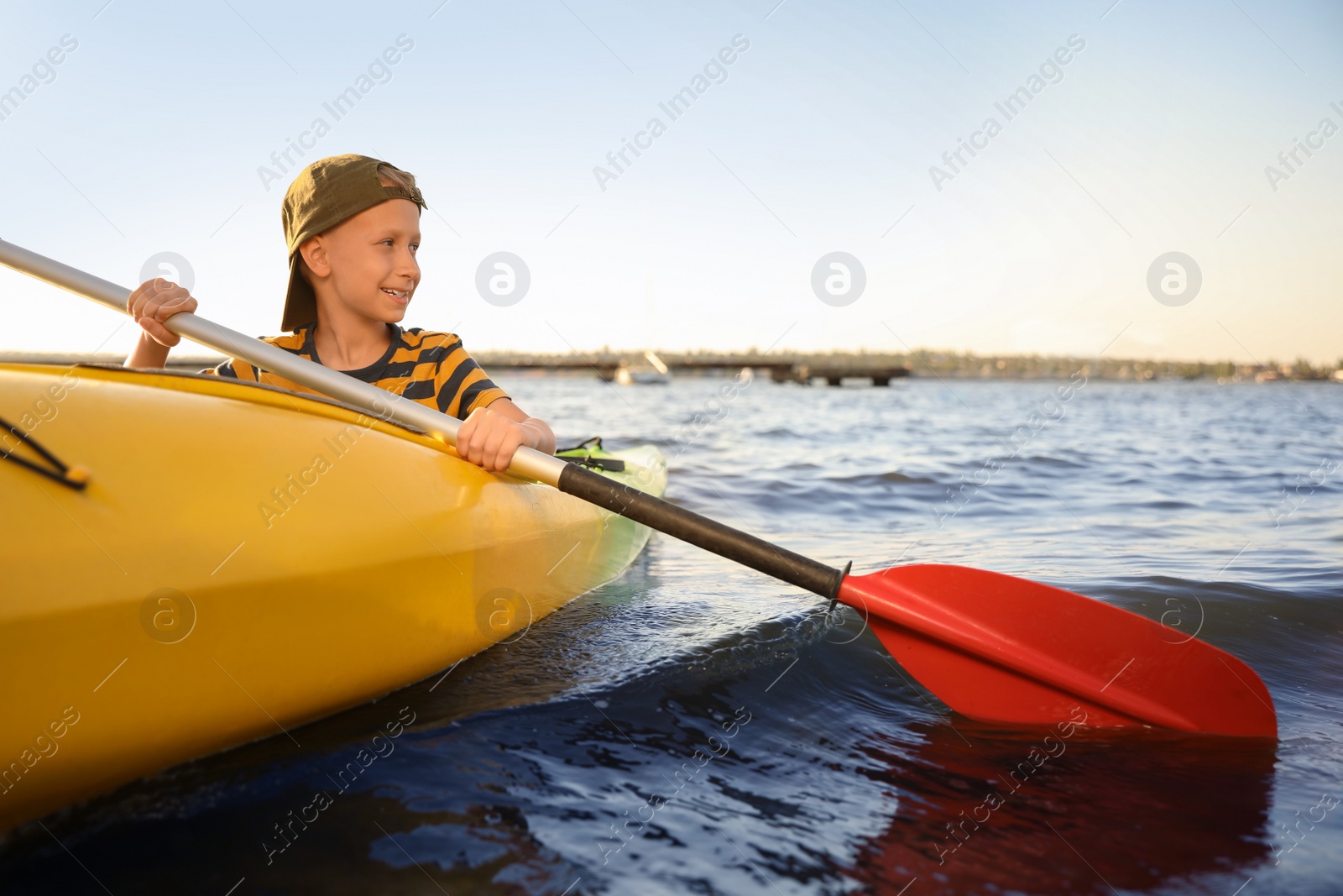 Photo of Happy little boy kayaking on river. Summer camp activity