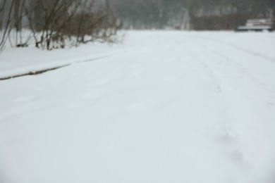 Photo of Blurred view of city street covered with snow in winter