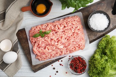 Photo of Raw chicken minced meat and ingredients on white wooden table, flat lay