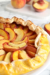 Photo of Delicious fresh peach pie on white table, closeup