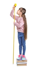 Little girl measuring her height on white background