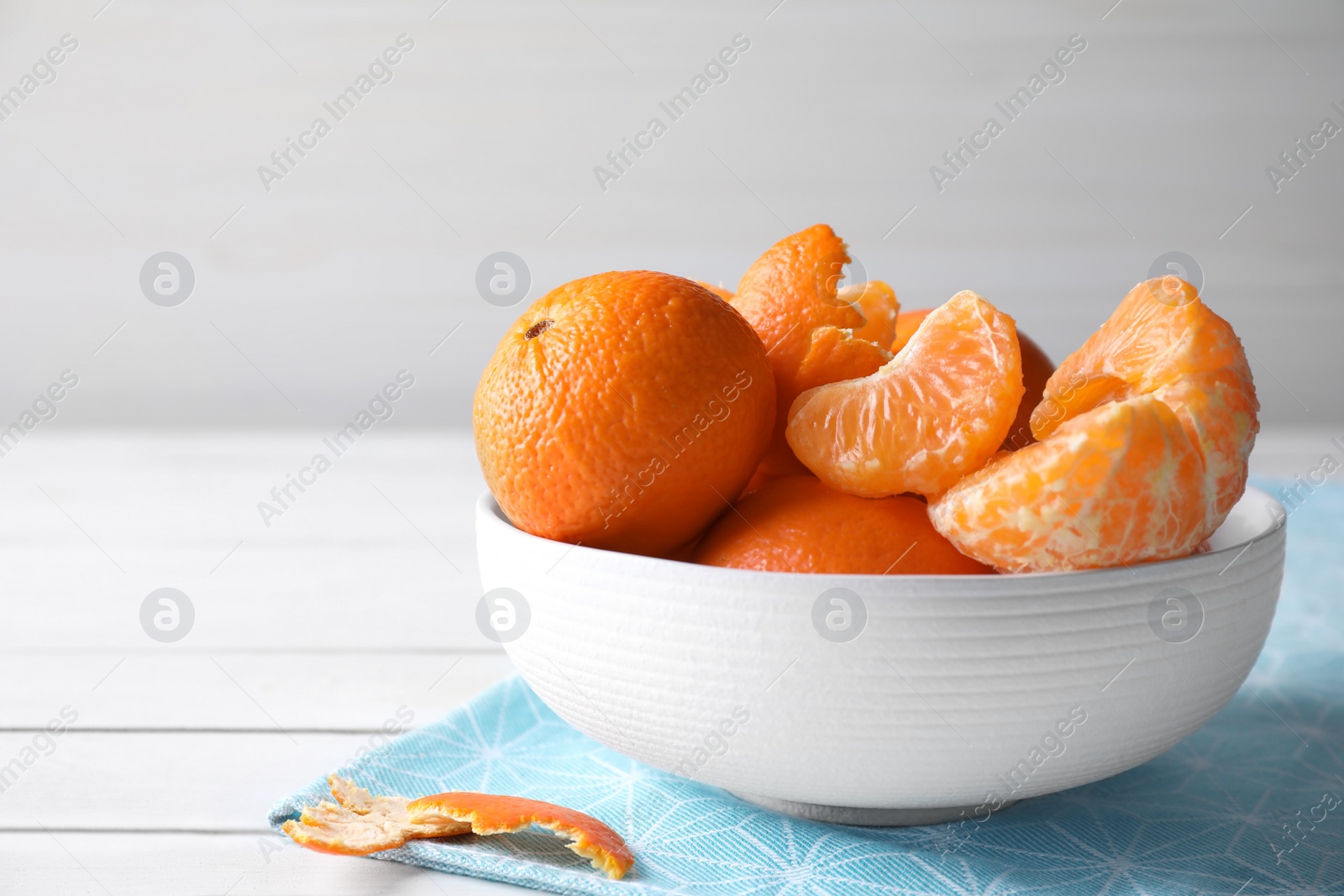 Photo of Delicious fresh ripe tangerines in bowl on white table