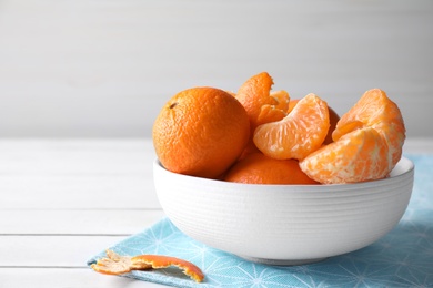 Delicious fresh ripe tangerines in bowl on white table