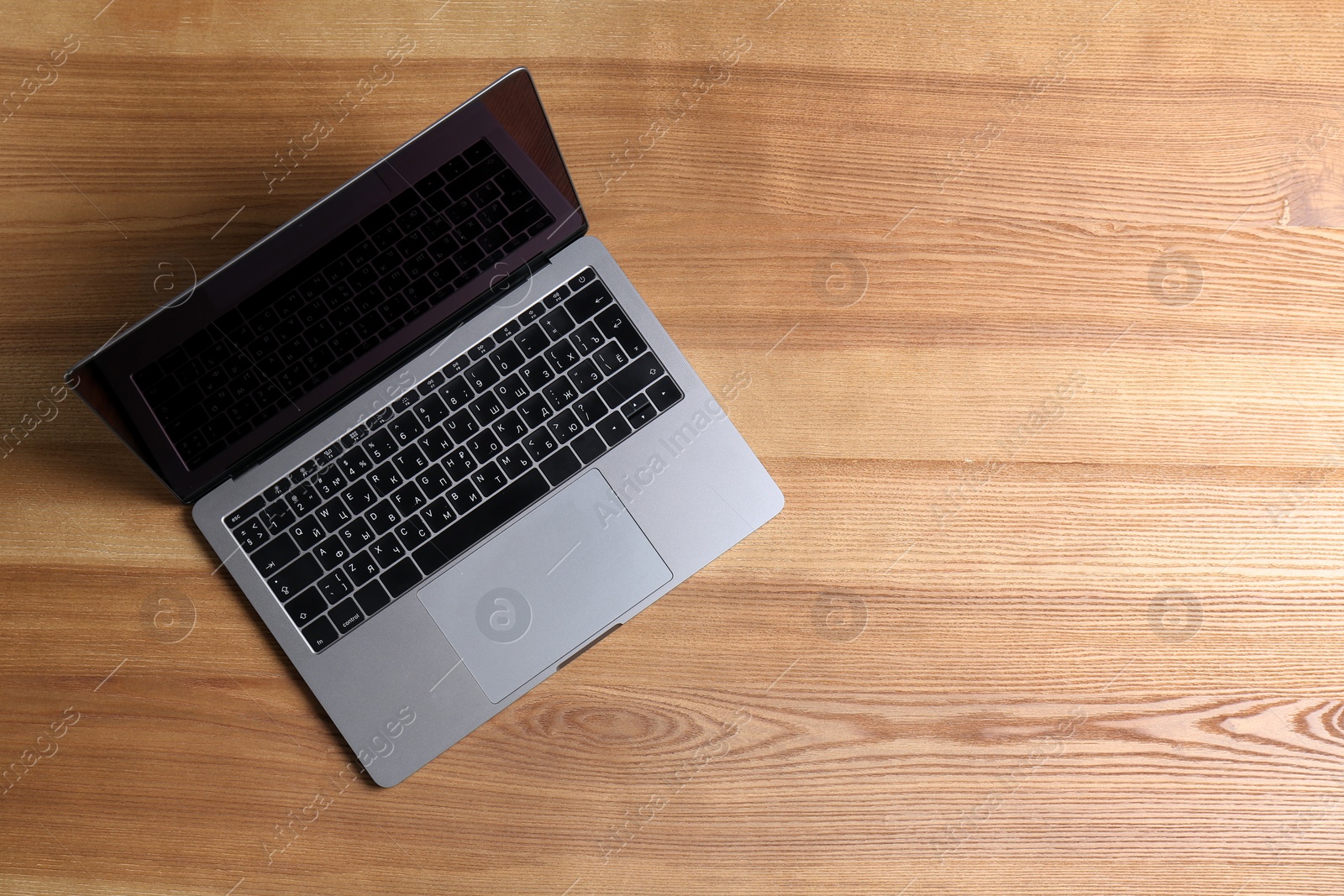 Photo of Modern laptop on wooden table, top view