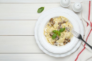 Delicious ravioli with mushrooms and cheese served on white wooden table, flat lay. Space for text