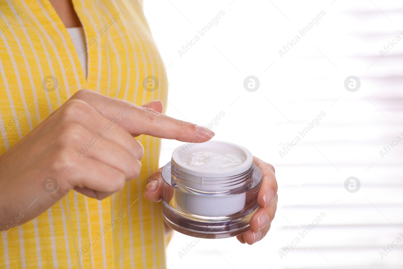 Photo of Woman with jar of moisturizing cream indoors, closeup. Space for text