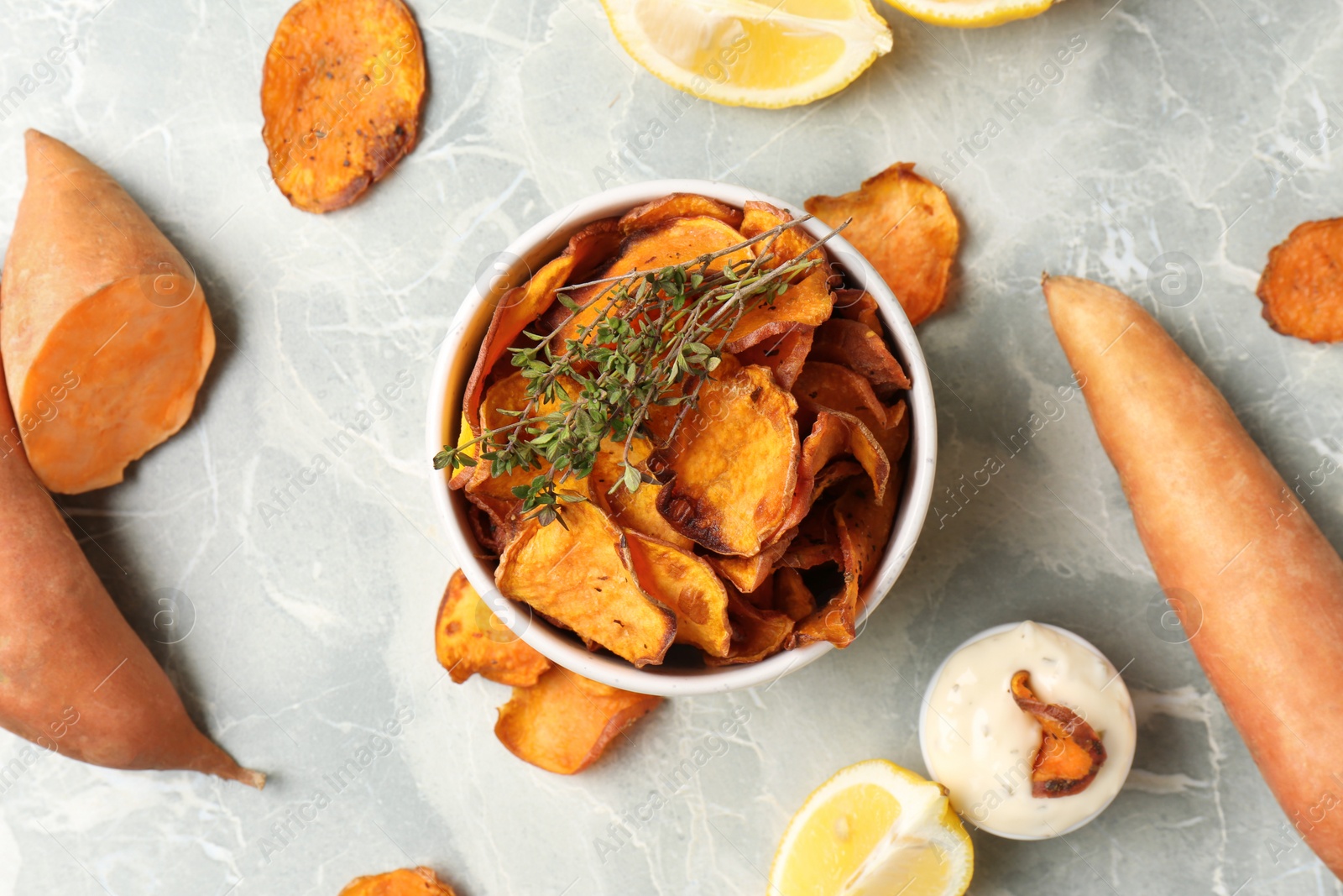 Photo of Flat lay composition with sweet potato chips on grey table