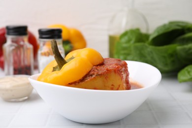 Photo of Delicious stuffed bell pepper on white tiled table