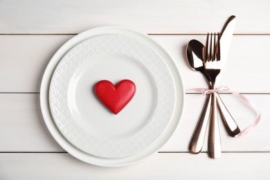 Photo of Beautiful place setting for romantic dinner on white table, flat lay. Valentine's day celebration