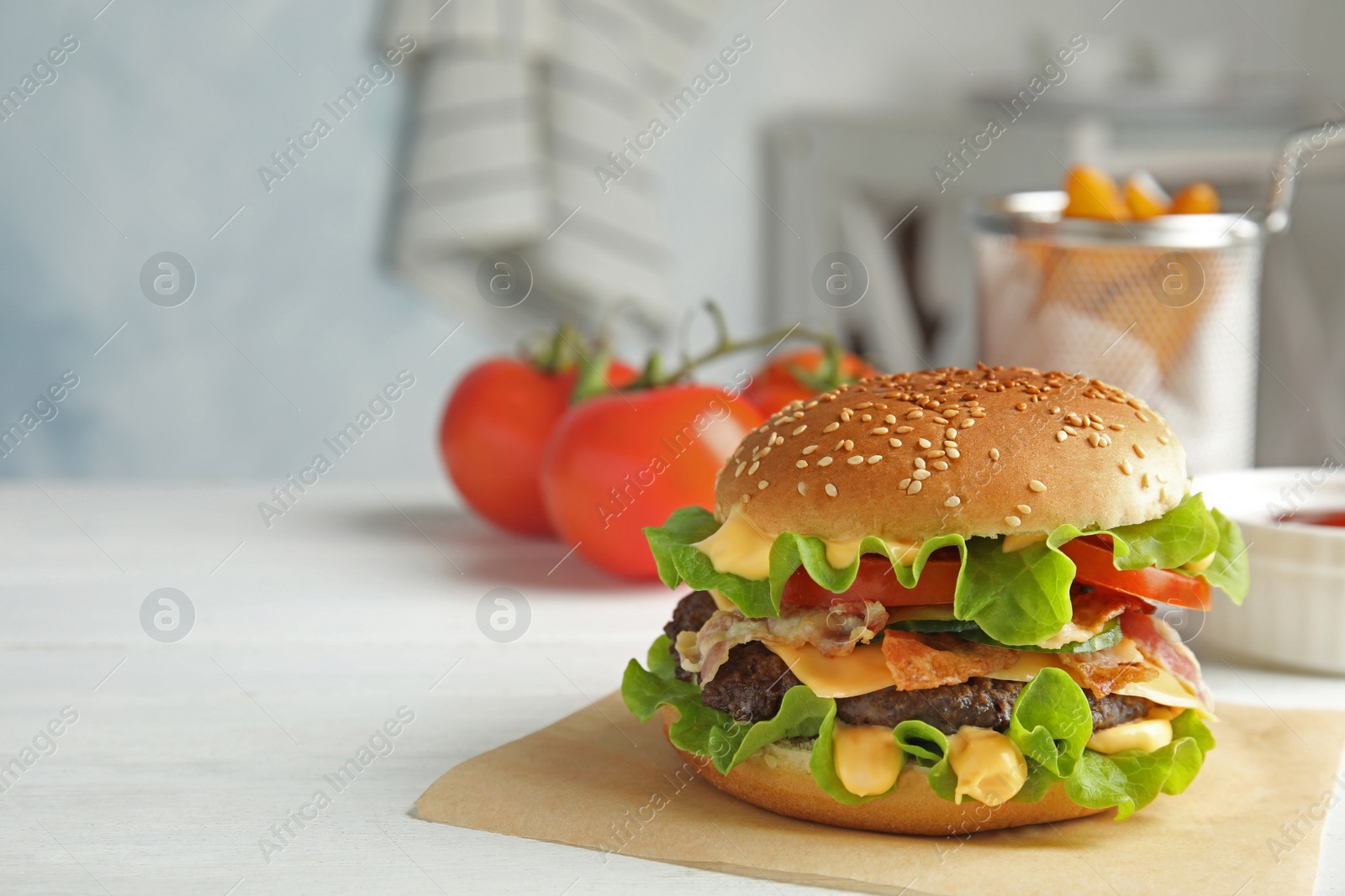 Photo of Tasty burger with bacon served on table. Space for text