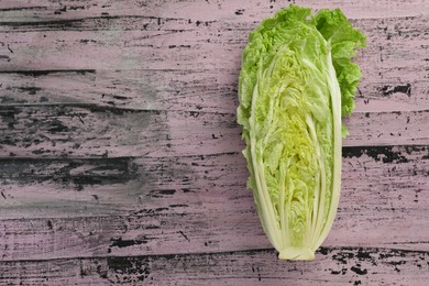 Photo of Cut fresh ripe Chinese cabbage on rustic table, top view. Space for text
