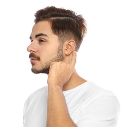 Photo of Young man adjusting hearing aid on white background
