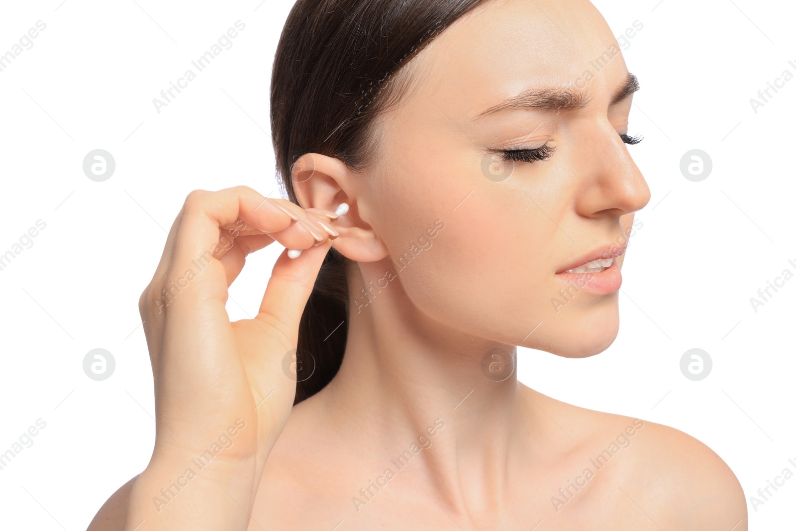 Photo of Young woman cleaning ear with cotton swab on white background, closeup