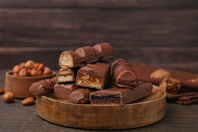 Photo of Pieces of different tasty chocolate bars on wooden table