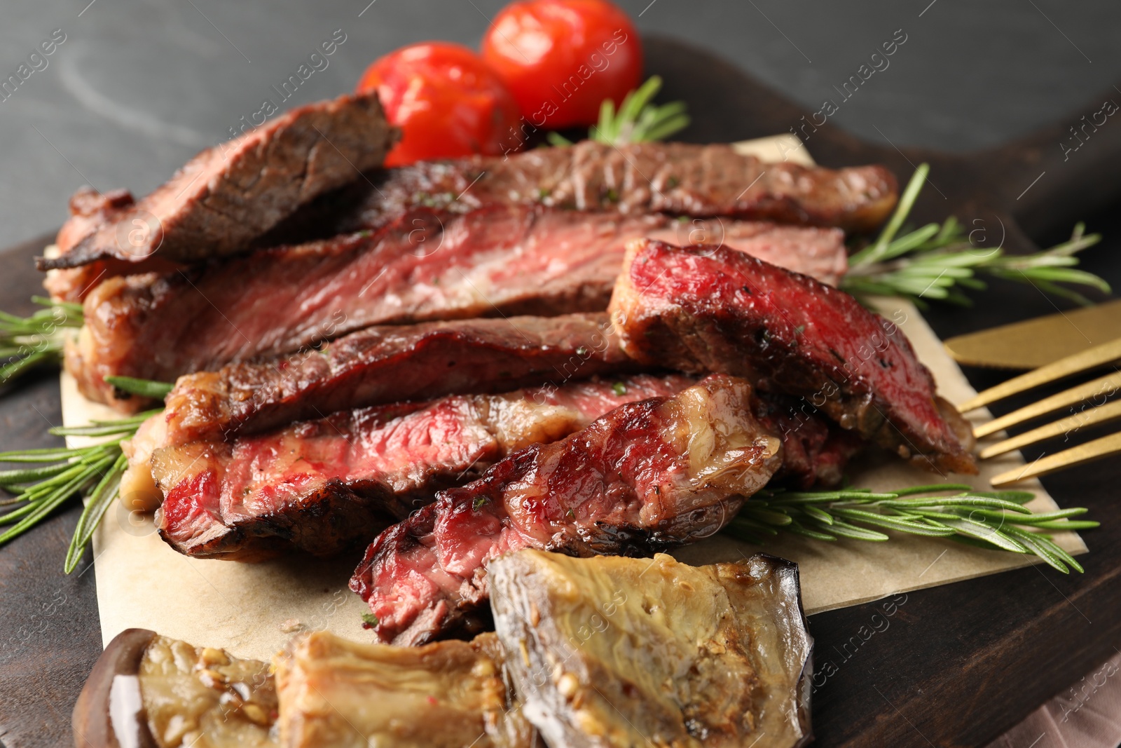 Photo of Delicious grilled beef with vegetables and rosemary on table, closeup