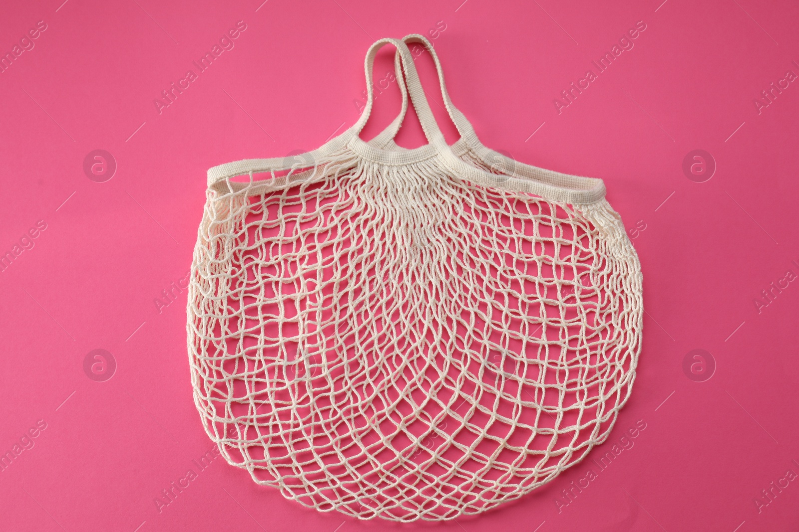 Photo of White string bag on bright pink background, top view