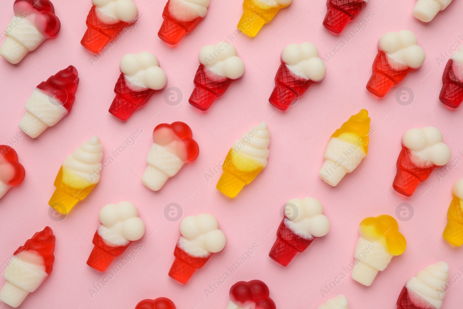 Photo of Tasty jelly candies in shape of ice cream on pink background, flat lay